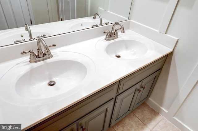 full bath with a sink, double vanity, and tile patterned floors