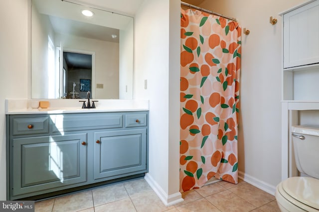 bathroom featuring baseboards, toilet, vanity, and tile patterned flooring