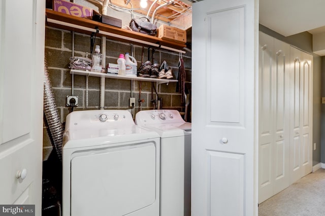 clothes washing area featuring washing machine and clothes dryer, laundry area, and carpet floors