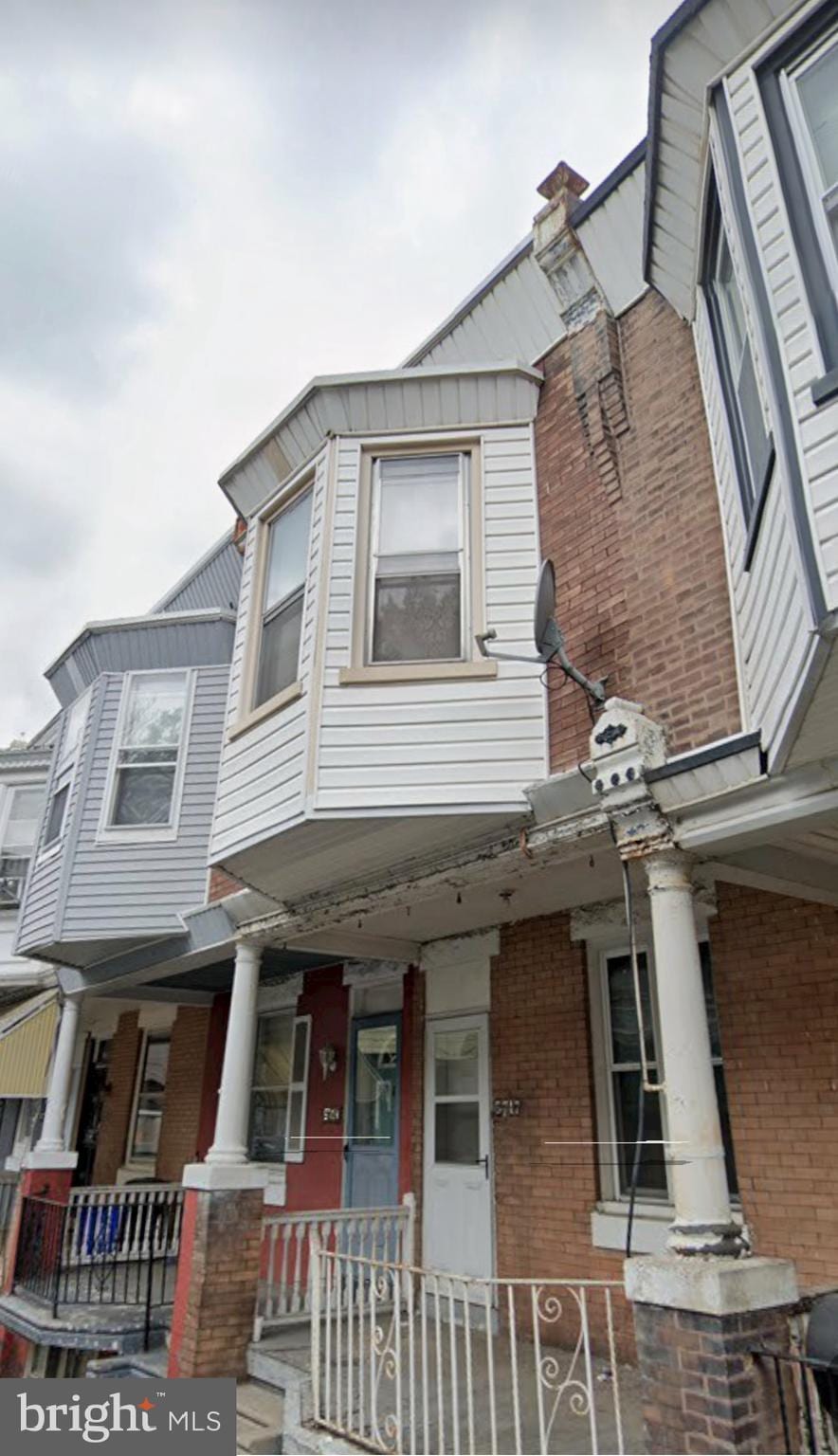 multi unit property featuring brick siding and a porch