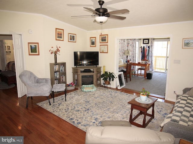 living area with hardwood / wood-style flooring, heating unit, and crown molding