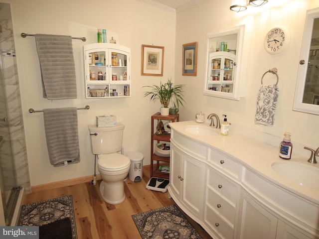 full bath featuring toilet, wood finished floors, a shower with door, and a sink