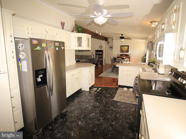 kitchen featuring light countertops, vaulted ceiling, white cabinets, stainless steel appliances, and a sink