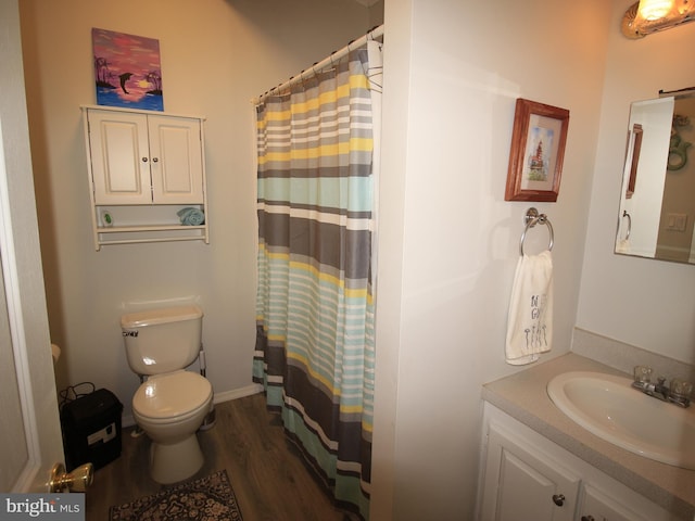 bathroom with vanity, curtained shower, toilet, and wood finished floors