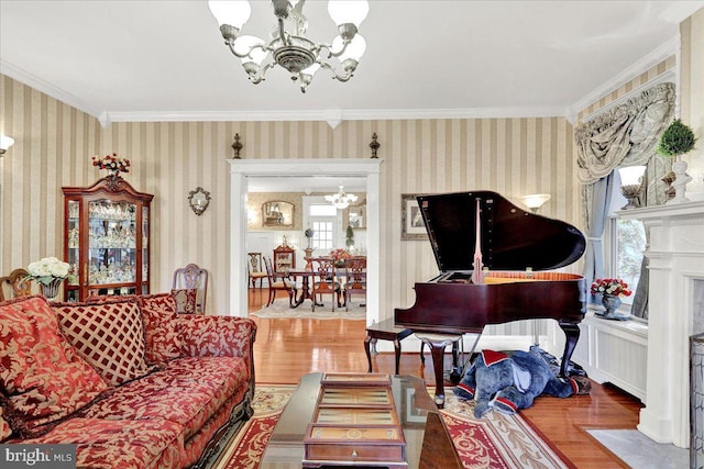 living area featuring a notable chandelier, wood finished floors, and wallpapered walls