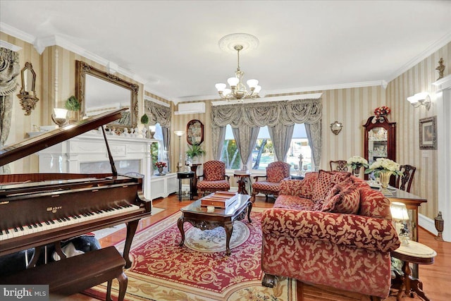 living room with wallpapered walls, crown molding, wood finished floors, and a chandelier