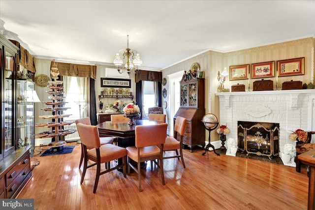 dining area with hardwood / wood-style flooring, a notable chandelier, crown molding, and a wealth of natural light