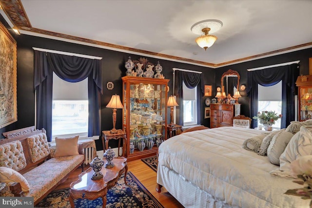 bedroom featuring crown molding and wood finished floors