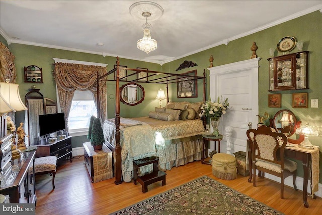 bedroom with a chandelier, wood finished floors, and crown molding