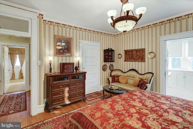 bedroom with wallpapered walls, multiple windows, and wood finished floors