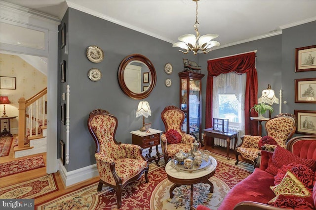 living area with a notable chandelier, stairway, wood finished floors, and ornamental molding