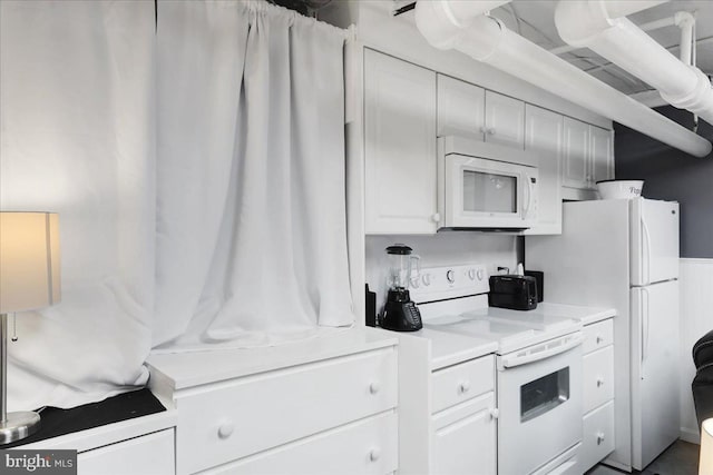 kitchen featuring white appliances, white cabinetry, and light countertops