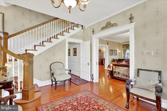 interior space with wallpapered walls, stairway, wood finished floors, and a chandelier