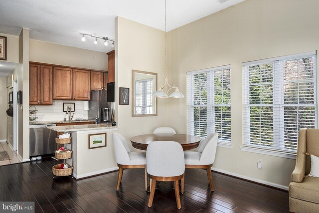 dining space with baseboards, plenty of natural light, and dark wood-style flooring