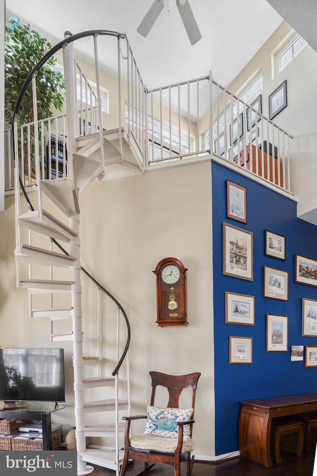 stairs with a high ceiling, a healthy amount of sunlight, and ceiling fan