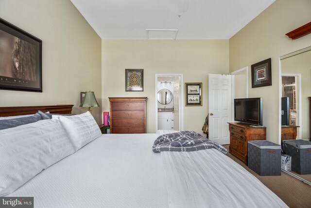 carpeted bedroom with attic access and ensuite bath