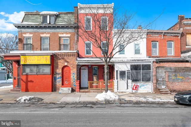 view of front of house with mansard roof and brick siding