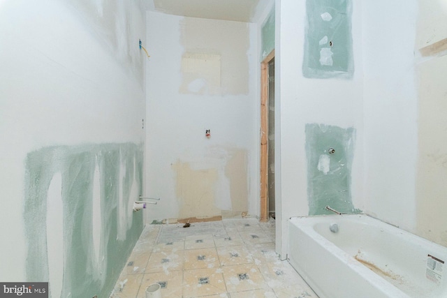 bathroom with tile patterned flooring and a tub to relax in