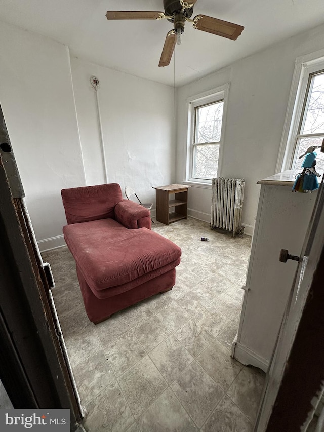 sitting room with a wealth of natural light, radiator heating unit, and baseboards