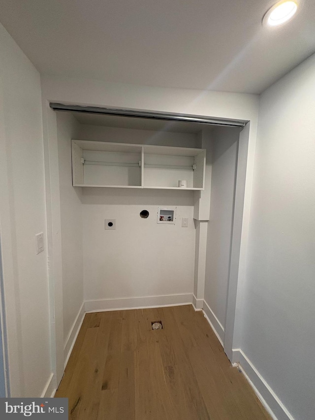 laundry area featuring electric dryer hookup, washer hookup, wood finished floors, baseboards, and laundry area