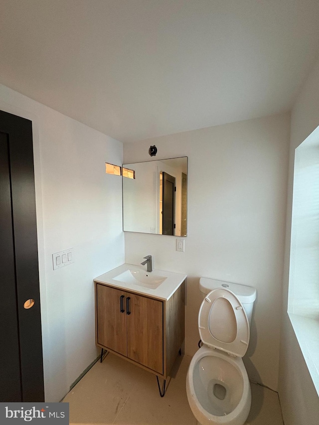 bathroom featuring vanity, toilet, and concrete floors