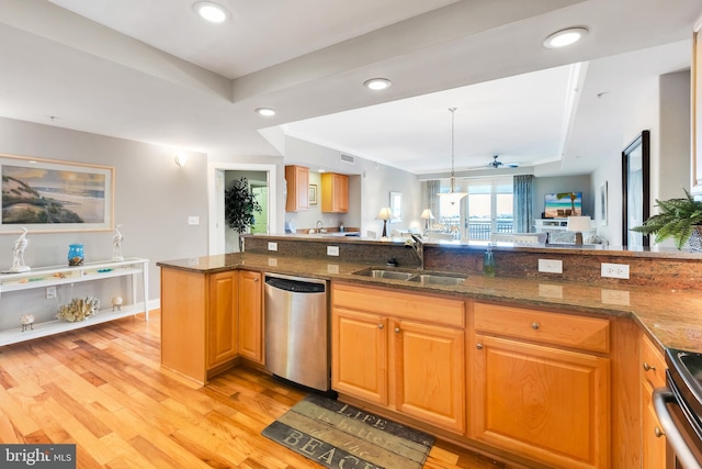 kitchen featuring a sink, dark stone counters, light wood-type flooring, and dishwasher