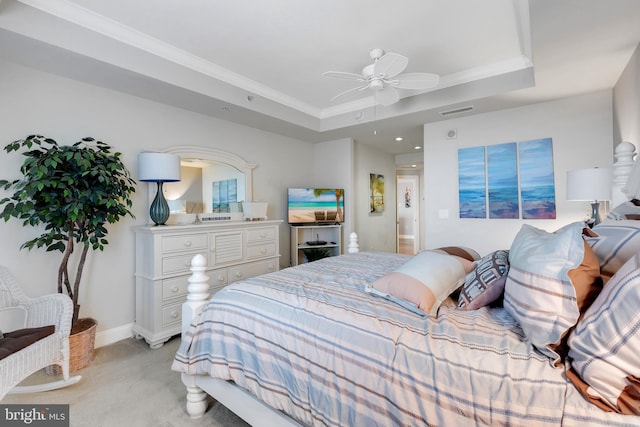 bedroom with baseboards, visible vents, a tray ceiling, ornamental molding, and light colored carpet