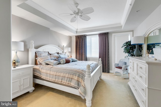 bedroom with a tray ceiling, light carpet, and ceiling fan