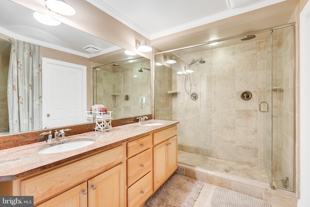 bathroom featuring crown molding, double vanity, a shower stall, and a sink