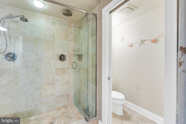 bathroom featuring tile patterned flooring, a shower stall, toilet, and baseboards