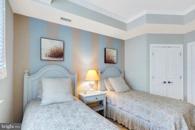 bedroom featuring wallpapered walls, visible vents, a closet, and ornamental molding