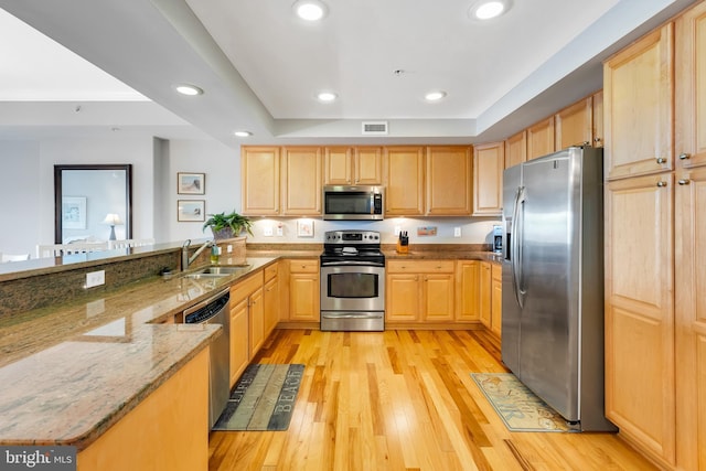 kitchen with visible vents, light brown cabinets, stainless steel appliances, and a sink