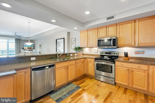 kitchen with light wood finished floors, visible vents, light brown cabinets, stainless steel appliances, and a sink