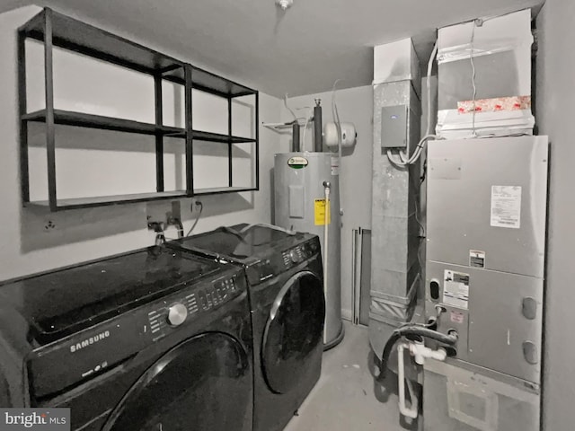 laundry room featuring heating unit, electric water heater, independent washer and dryer, and laundry area