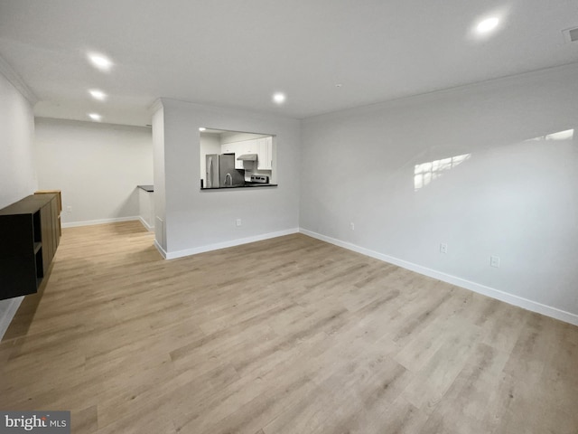 unfurnished living room with visible vents, light wood-style flooring, ornamental molding, recessed lighting, and baseboards