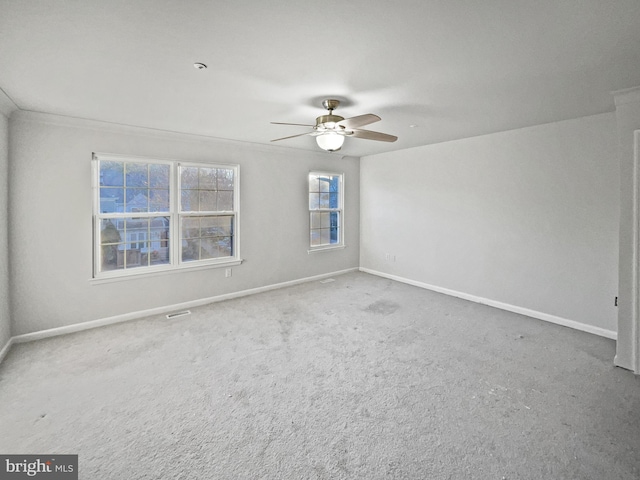 carpeted empty room with visible vents, baseboards, and ceiling fan