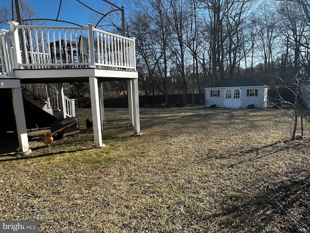 view of yard with a wooden deck, an outbuilding, and stairs