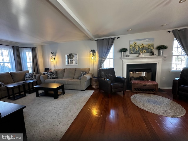 living area with a multi sided fireplace, beam ceiling, and hardwood / wood-style floors