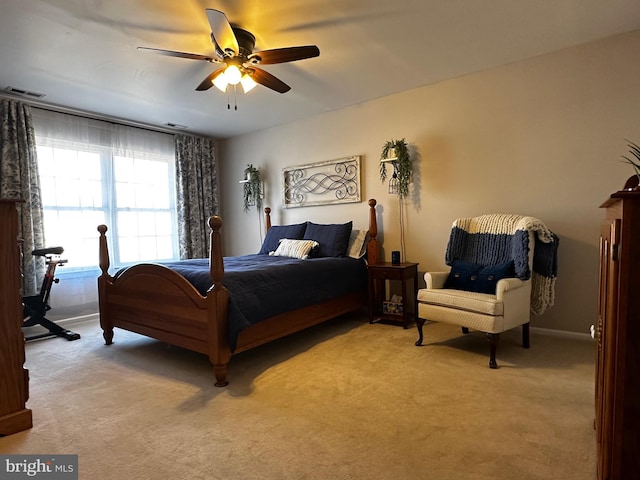 bedroom with visible vents, light carpet, baseboards, and ceiling fan