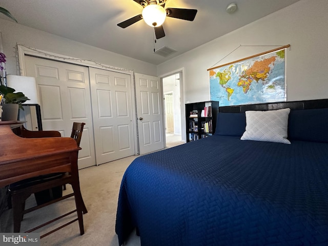 carpeted bedroom with a closet, visible vents, and ceiling fan