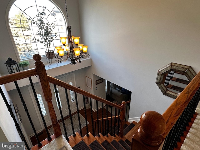 stairs with baseboards, an inviting chandelier, and wood finished floors