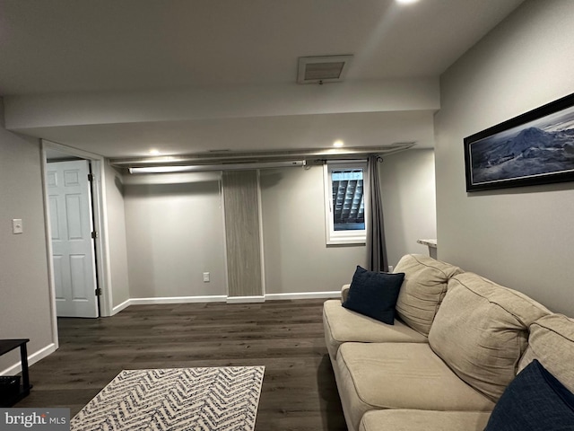 living area featuring dark wood-type flooring and baseboards