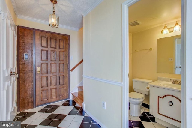 entrance foyer featuring visible vents, crown molding, stairway, a textured ceiling, and dark tile patterned flooring