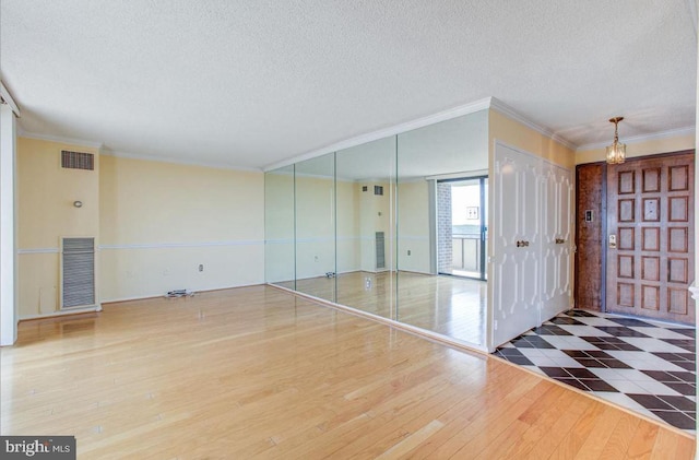 entryway with visible vents, a textured ceiling, and wood finished floors