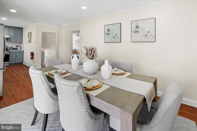 dining room featuring baseboards, a baseboard radiator, recessed lighting, dark wood-type flooring, and crown molding