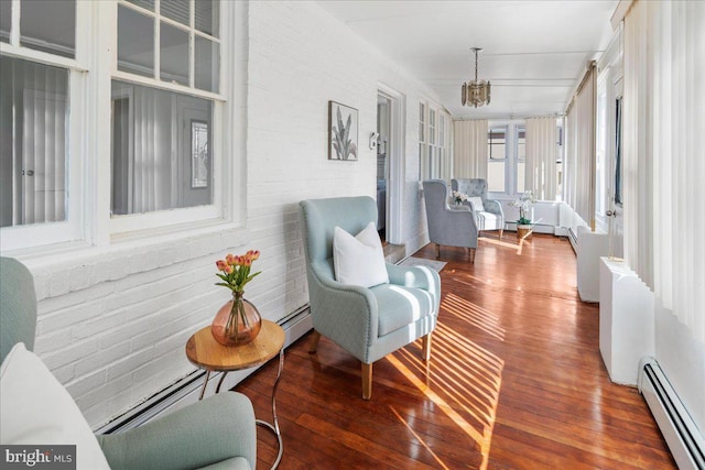 sunroom / solarium featuring a notable chandelier, baseboard heating, and a baseboard radiator