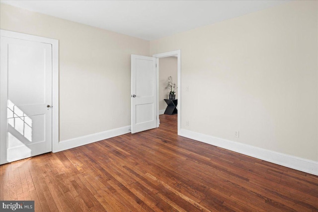 unfurnished bedroom with baseboards and hardwood / wood-style flooring