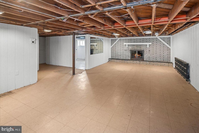 basement featuring tile patterned floors and a brick fireplace