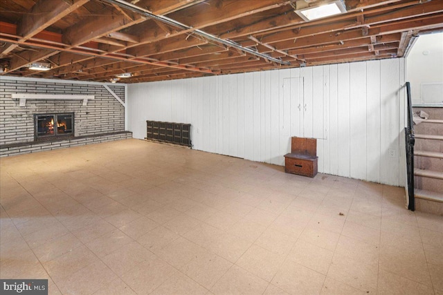 finished below grade area featuring tile patterned floors, a fireplace, and stairs