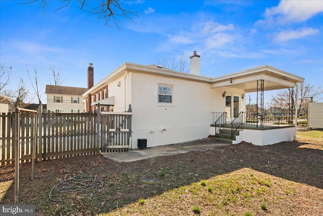 rear view of property with fence and a chimney